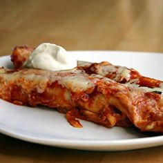 a white plate topped with lasagna covered in sauce