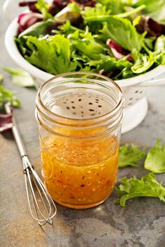 a salad with dressing in a jar next to it