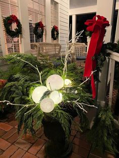 a potted plant with christmas decorations on the front porch