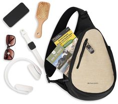 the contents of a travel bag including headphones, sunglasses and hairbrush are laid out