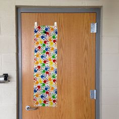 the door is decorated with colorful handprints and has a paper towel hanging on it