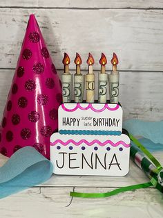 a birthday cake with lit candles on it next to a party hat and streamers