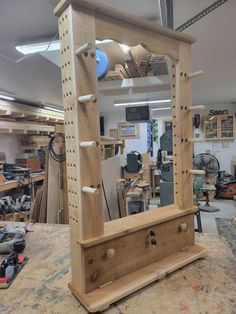 a mirror sitting on top of a wooden table in a room filled with lots of tools