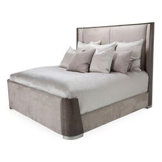 a bed with four pillows on top of it and two nightstands underneath the headboard