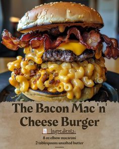 the bacon mac'n cheese burger is stacked high on a black plate with a piece of parchment paper