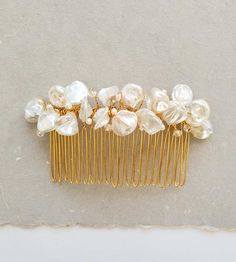 Truly luxurious, a freshwater pearl petal hair comb made for the timeless bride. Flower petal like texture and iridescent shimmer imparted by keshi pearls is so feminine. Sparkling Swarovski crystals and dainty freshwater pearls add addition dimension across the headpiece. A delight for the modern romantic.



The Emmaline comb can be worn to accent an up-do or with attached to a veil; it's an fresh take on a traditional pearl bridal comb. Wear it for a wedding, then again for anniversaries and Elegant Bridal Hair, Bridal Things, Timeless Bride, Pearl Bridal Comb, Bridal Hair Down, Pearl Hair Comb, Bridal Hair Combs Pearl, Gold Hair Comb, Pearl Hair Combs