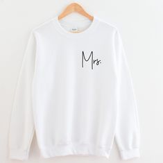 a white sweatshirt with the word m is written in cursive writing on it