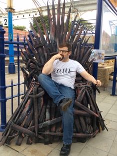 a man sitting on top of a giant iron throne