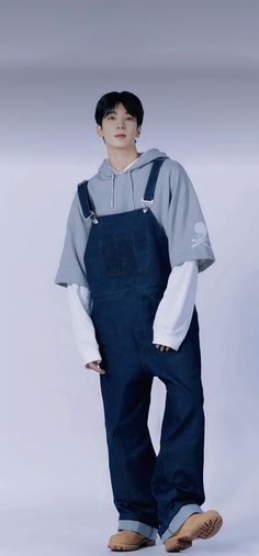 a male model in overalls and a hoodie