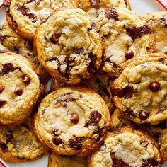 a plate full of chocolate chip cookies sitting on top of a white and red table