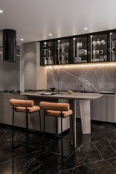 a modern kitchen with marble counter tops and bar stools