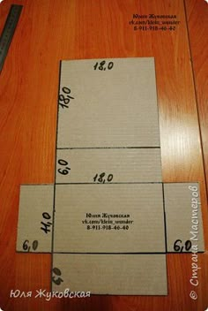 four pieces of cardboard sitting on top of a wooden floor next to a measuring ruler