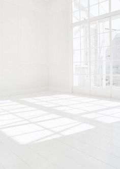 an empty room with white walls and floor