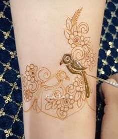 a henna tattoo is being applied on a woman's leg with gold glitters