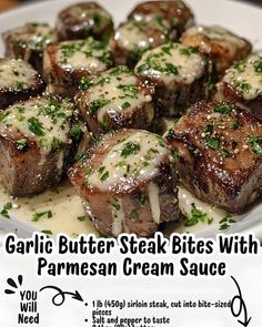 garlic butter steak bites with parmesan cream sauce are served on a white plate