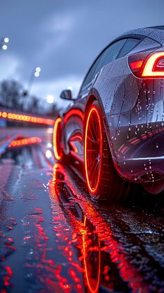 a car is parked on the side of the road with its lights reflecting off in the wet pavement