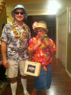 a man and woman are dressed up in hawaiian clothing for the occasion, while they pose for a photo