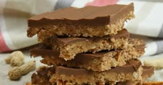 three pieces of chocolate peanut butter granola bars stacked on top of each other with nuts