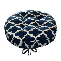 a blue and white round chair cushion with an intricate design on the front, tied in a knot