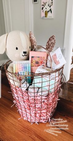 a teddy bear sitting in a basket filled with personal care items on a wooden floor