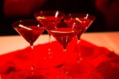 three martini glasses sitting on top of a red tray