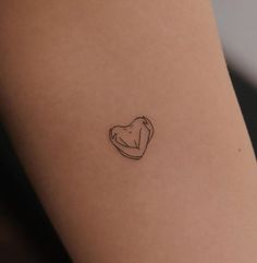 a small heart tattoo on the back of a woman's leg, which is drawn in black ink