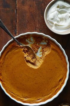 a bowl of pumpkin pie with a spoon in it