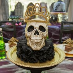 a cake with a skull wearing a crown on it's head sitting on top of a plate