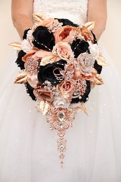 the bride's bouquet is made up of black roses, peach and gold leaves