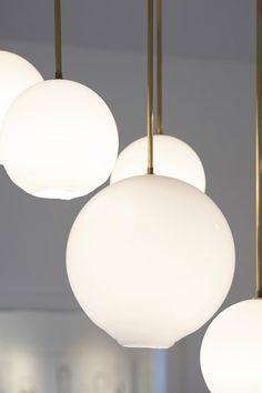 several white lights hanging from a ceiling in a room with other light fixtures and lighting fixtures