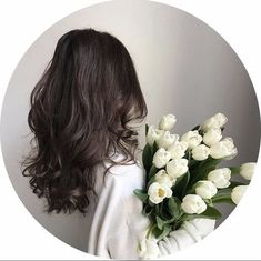 a woman holding a bouquet of white tulips