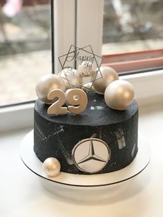 a black and white cake sitting on top of a window sill next to a window