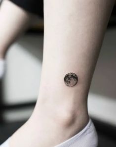 a woman's ankle with a small moon tattoo on her left side ribcage