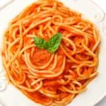 a white plate topped with spaghetti and sauce