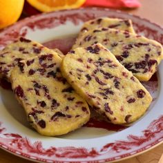 three cookies on a plate with oranges in the background