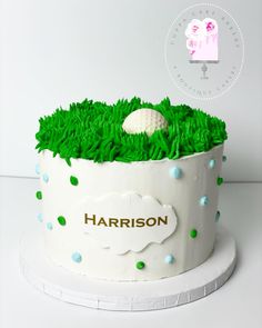 a golf themed birthday cake with green grass and a white ball on top that says harrison