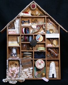 a doll house made out of wooden boxes filled with assorted items and buttons on black background