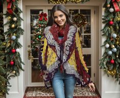 a woman wearing a scarf and jeans is walking down the hall with christmas decorations around her