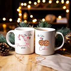 two coffee mugs decorated with christmas cookies and candy canes