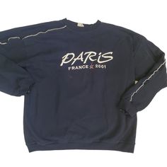 This vintage navy blue sweatshirt features an embroidered design of the Eiffel Tower and the word "Paris France". The sweatshirt has a classic fit with long sleeves, pullover closure, and a crew neckline. It is made of 100% cotton knit material that is machine washable. Quality fabric with white accent tuxedo stripe giving it an athletic style  This sweatshirt is perfect for world travelers and Paris enthusiasts. It is pre-owned with some flaws, but still in good condition. The size is M/L with Navy Blue Sweatshirt, Athletic Style, The Eiffel Tower, Blue Sweatshirt, Saree Look, White Accents, White Paint, Athletic Fashion, Saree Styles