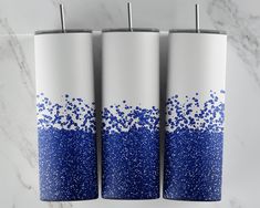 three blue and white vases on a marble counter with silver sprinkles