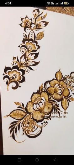 an intricately designed piece of paper with gold flowers on it