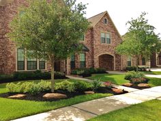 a brick house with landscaping in front of it