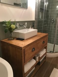 a bathroom with a sink, mirror and shower stall in the corner next to it