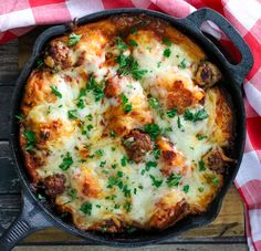 a skillet filled with meat and cheese on top of a checkered table cloth