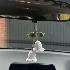 the interior of a car is decorated with white crochet and hanging from it's rearview mirror