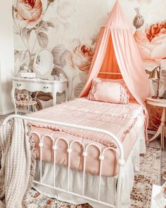 a bedroom with pink flowers on the wall and white bedding, along with an orange canopy