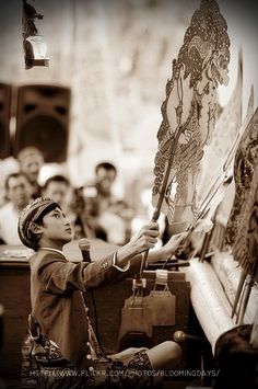 a young boy is drawing on an easel in front of a group of people