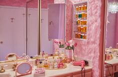 a bathroom with pink walls and vanity mirror