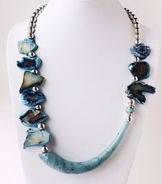 This blue agate and glass horn necklace is quite a change for me in terms of design! Most of my necklaces are symmetrical and this statement piece is striking in the asymmetrical placement of the beads and horn. I found this Agua glass horn at a show a year ago and never found beads to use with it until now! I love the contrast between the organic blues and the smooth surface of the glass. Sterling Silver round beads add the elegance and pull the design together. The toggle clasp has a hammered Organic Necklace, Asymmetrical Necklace, Silver Beaded Necklace, Fan Necklace, Unique Jewelry Gifts, Organic Jewelry, Horn Necklace, Silver Necklace Statement, Silver Bead Necklace